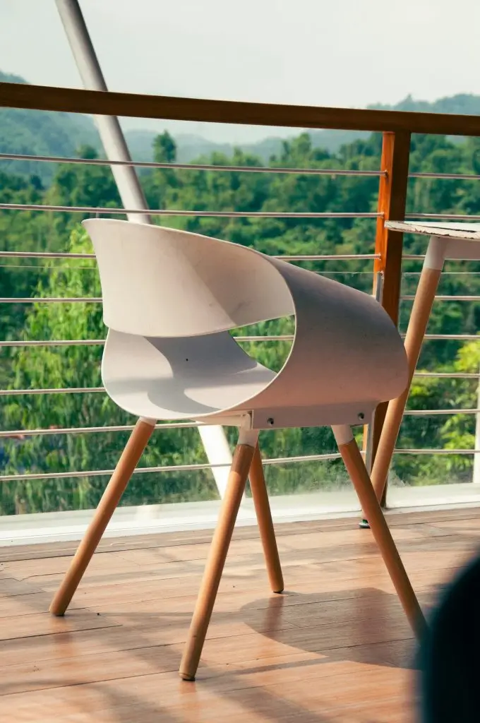 Silla blanca sobre tarima de madera: un espacio exterior sencillo y moderno