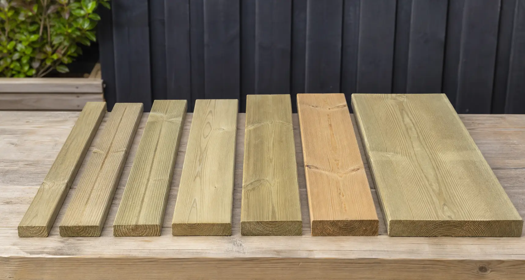 Tablas de tarima exterior de distintos anchos comparadas con cinta métrica y hoja de planificación